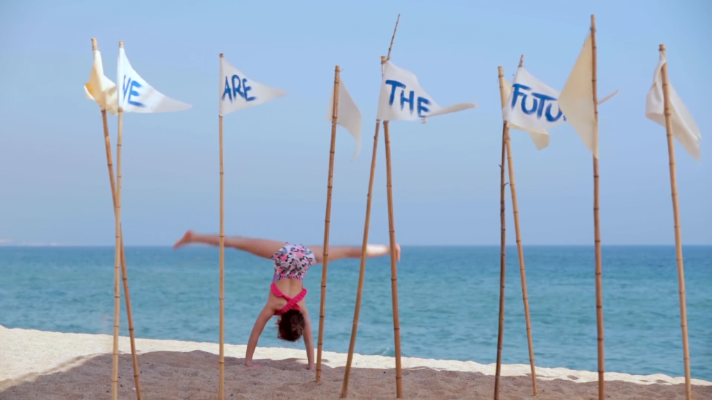 niña haciendo la voltereta en la playa